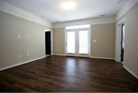A room with wooden floors and a black door.