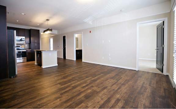 A spacious room with wooden floors and white walls.