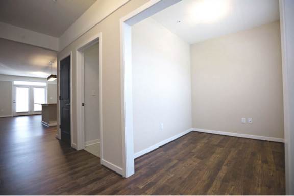 A room with wood flooring and white walls.