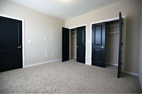A room with black doors and carpeted floor.