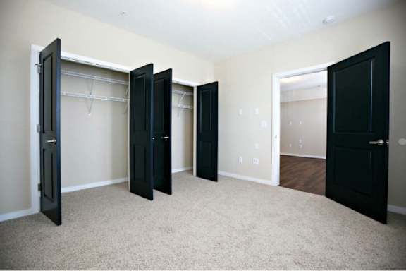 A room with four black doors and a white door.
