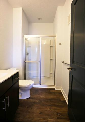 A white toilet sits in a bathroom next to a walk-in shower.