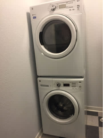 A white washing machine and dryer stacked on top of each other.