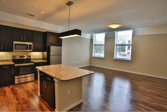 A kitchen with dark wood cabinets and a granite countertop.