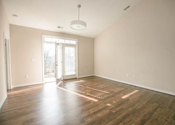 A room with wooden flooring and a ceiling light.