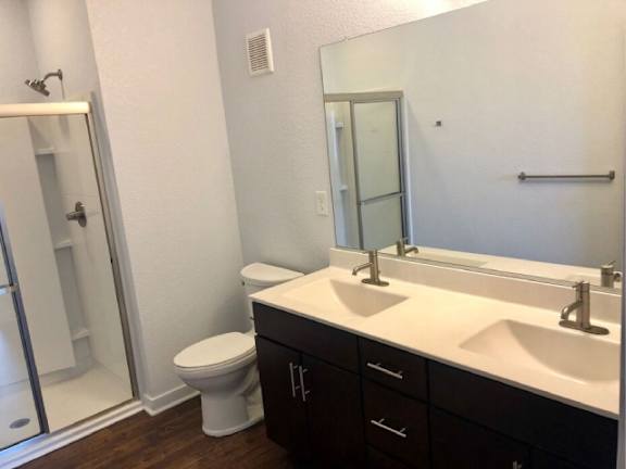 A bathroom with a toilet, sink, and mirror.