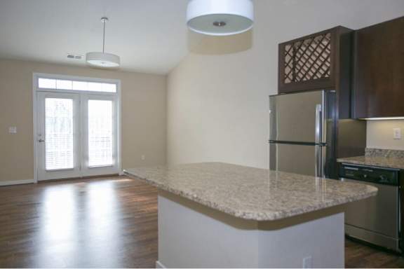 A kitchen with a granite countertop and stainless steel appliances.