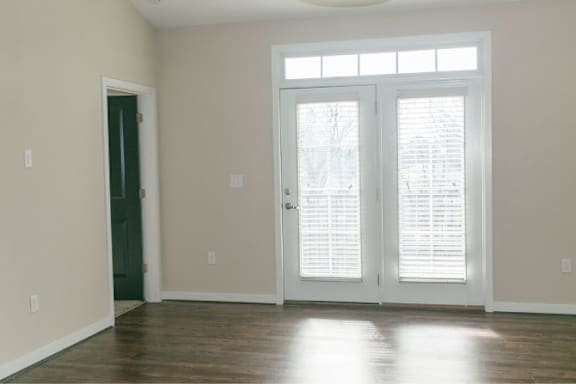 A room with a green door and a white door with windows.