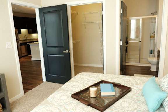 A bedroom with a bed, a tray with candle and book, and a wardrobe.