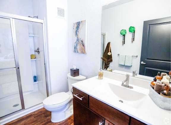 A white sink in a bathroom with a toilet and a shower.