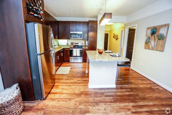 A kitchen with a refrigerator, stove, and island.