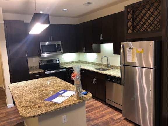 A kitchen with granite countertops and stainless steel appliances.