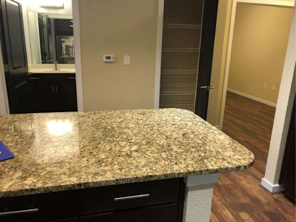 A granite countertop with a purple placemat on it.