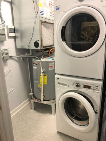 A washing machine is in a small room with a dryer and a washing machine.