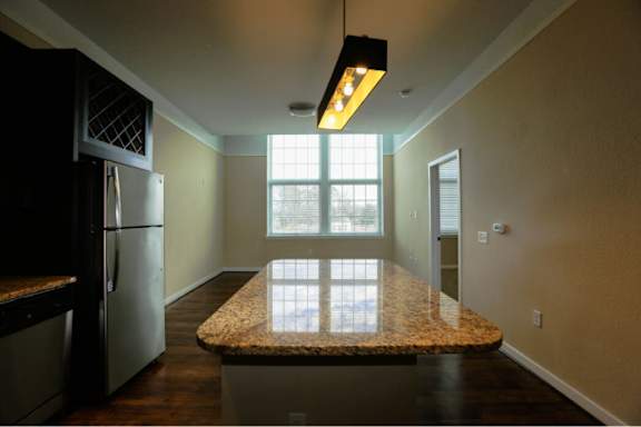A kitchen with granite countertops and a large window.