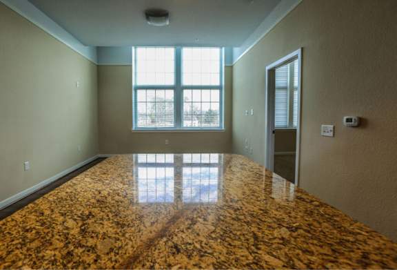 A room with a marble floor and a window letting in light.