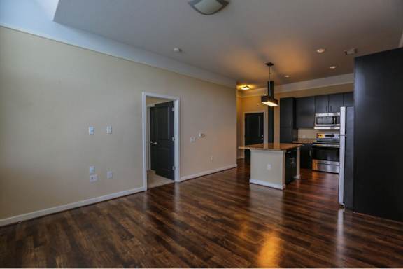 A kitchen area with a white fridge and black cabinets.