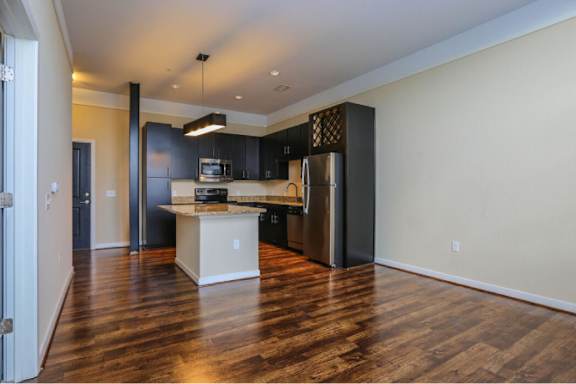 A kitchen with a white island and stainless steel appliances.