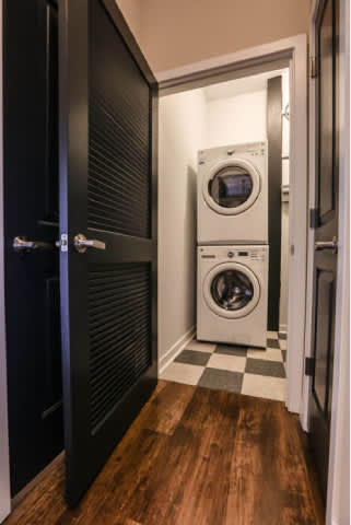 A black door is open to a laundry room with a washer and dryer.