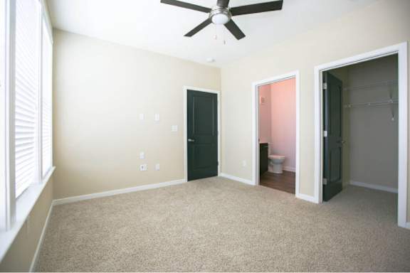A room with a ceiling fan and a carpeted floor.