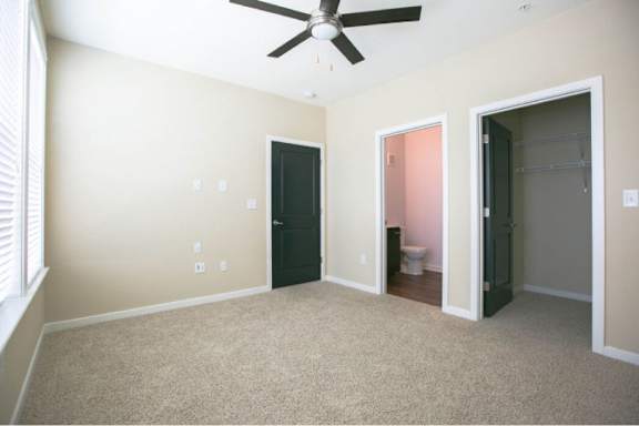 A room with a ceiling fan and a carpeted floor.