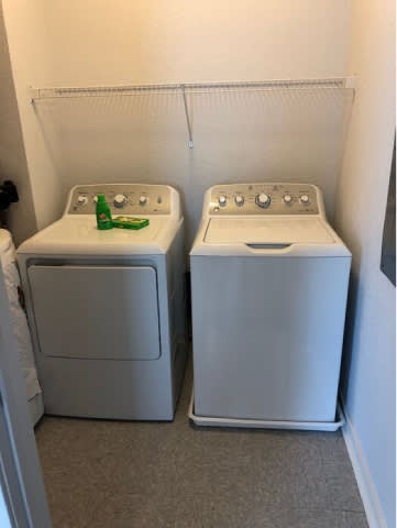 Two white washing machines in a small room.
