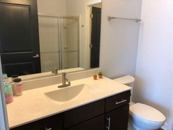 A bathroom with a white countertop and a white toilet.