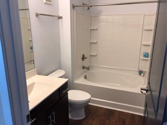 A white toilet sits next to a white sink in a small bathroom.
