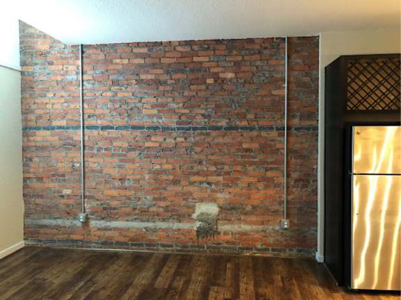 A room with a brick wall and a wooden floor.