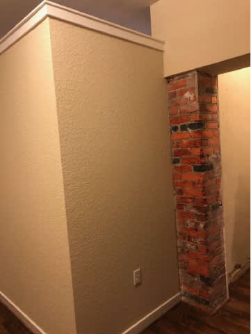 A white wall with a brick pillar.