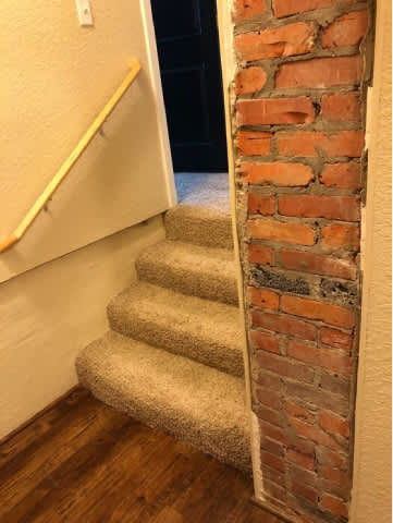 A staircase with a brick column on the side.
