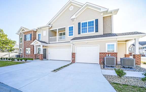 A large, two-story house with a garage and a driveway.