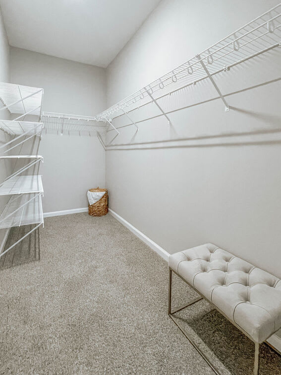 A room with a white bench and a white shelf.