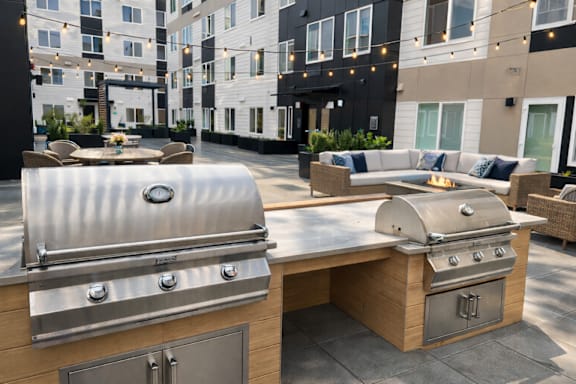 A stainless steel grill is on a wooden table.