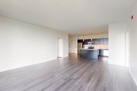 A large empty room with wooden floors and white walls.