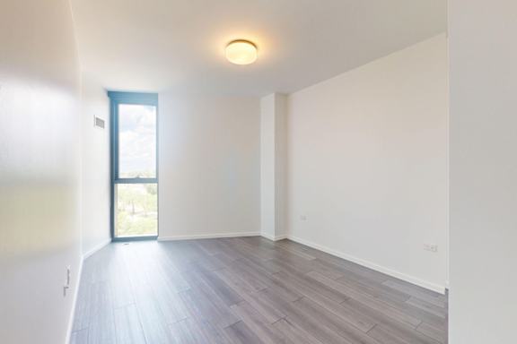 A room with a door leading outside and a light on the ceiling.