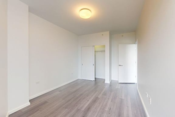 A room with wooden flooring and white walls.