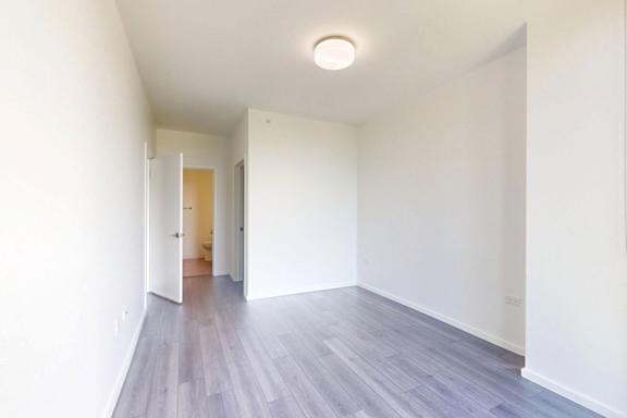 A room with a white wall and a grey floor.