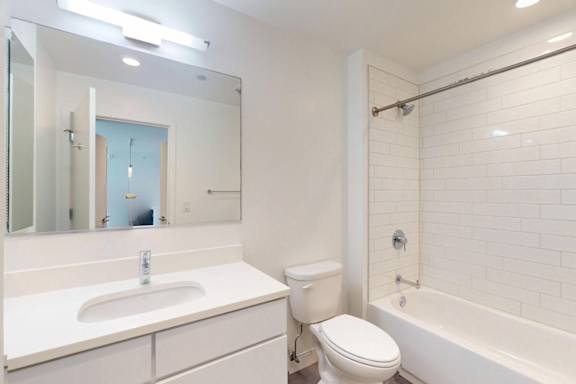 A white bathroom with a sink, toilet, and bathtub.