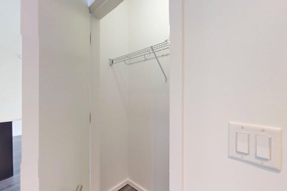 A white bathroom with a shower and a light switch.