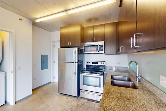 A kitchen with a stainless steel refrigerator, oven, and microwave.