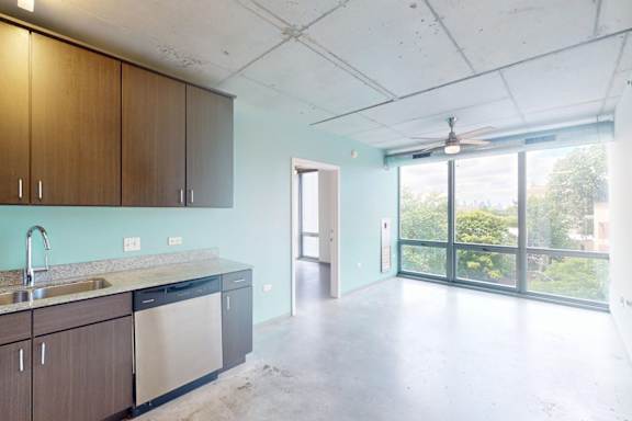 A kitchen with a sink, cabinets, and a window.
