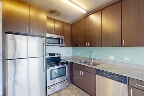 A kitchen with brown cabinets and stainless steel appliances.