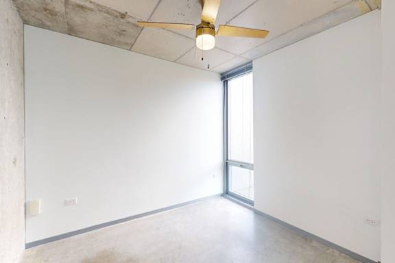 A room with a ceiling fan and a window.