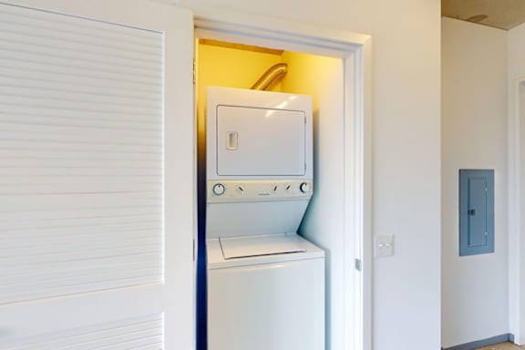 A white washing machine is in a small alcove.