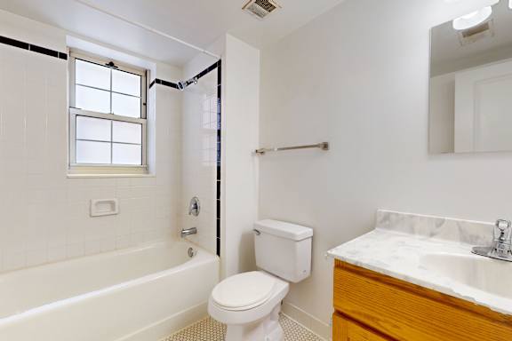 A white toilet sits next to a bathtub in a bathroom.