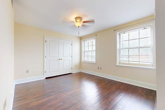 A room with a white door and a window with blinds.