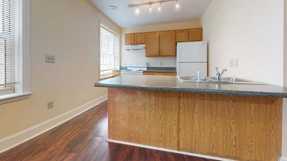 A kitchen with wooden cabinets and a granite countertop.