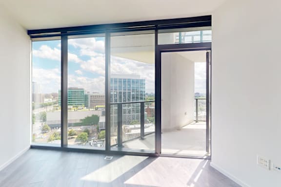 A room with a view of the city through large windows.