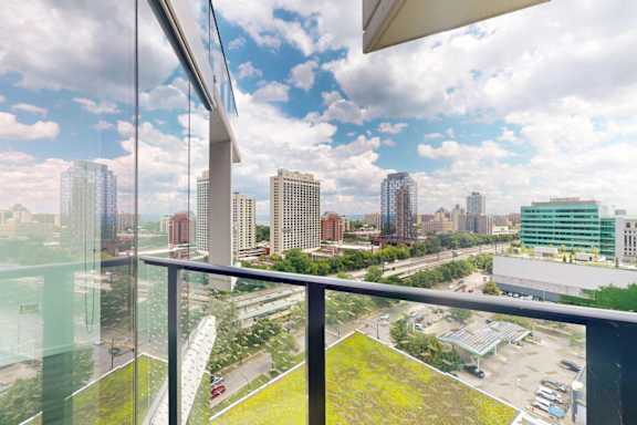 A cityscape is visible through a window with a green lawn in the foreground.